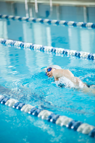 Young girl in goggles swimming front crawl stroke style - Foto, immagini