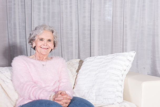 active female senior relaxing on couch - Photo, Image