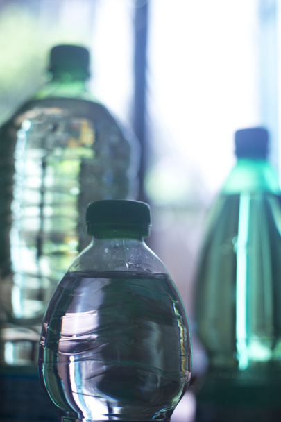 Пластикові пляшки води у віконному світлі
 - Фото, зображення
