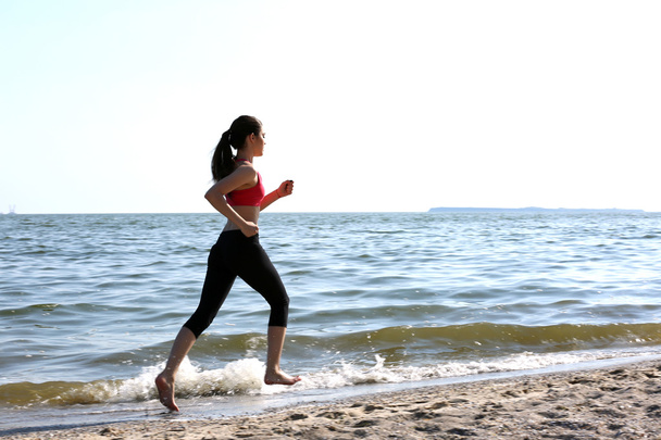 Young woman jogging on beach - Photo, Image