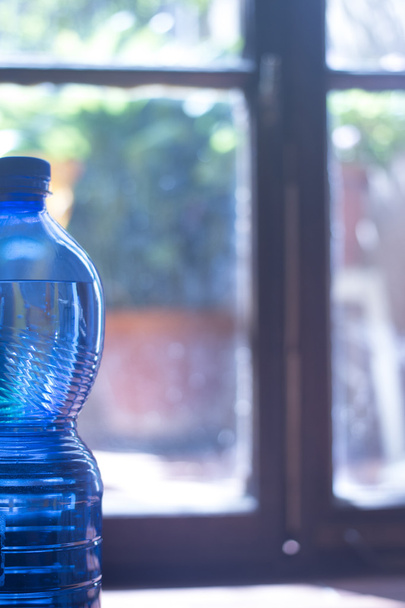 Plastová láhev s vodou v okně světlo - Fotografie, Obrázek