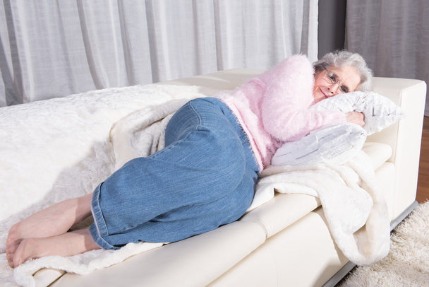Активна жінка старшого віку розслабляється на дивані
 - Фото, зображення