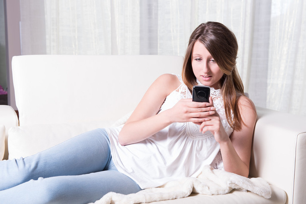 atractiva joven leyendo un mensaje de miedo en el teléfono inteligente
 - Foto, Imagen
