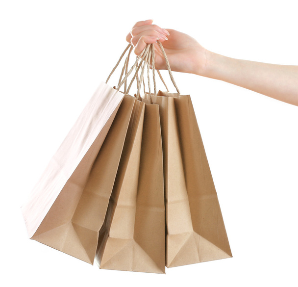 Female hand holding paper shopping bag isolated on white - Foto, imagen