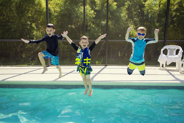 boys jumping into  pool - Foto, imagen