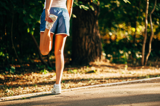 yong sporty woman streching her leg - Фото, изображение