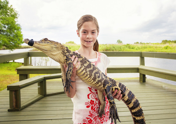girl holding a crocodile - Photo, Image