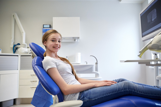happy patient girl at dental clinic office - Фото, изображение