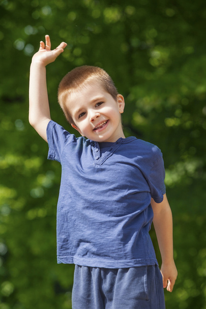 Cute boy outdoors, raised hand - Zdjęcie, obraz