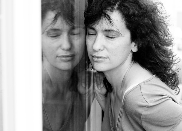 nő pózol közelében ablak - Fotó, kép