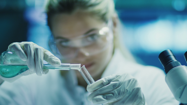 Mujer científica en gafas hace investigación química
 - Imágenes, Vídeo