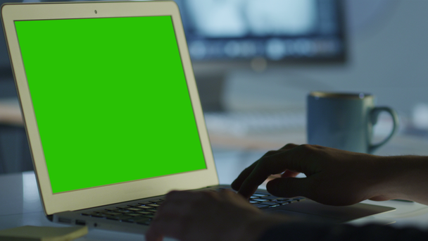 Программист работает в Office на ноутбуке с зеленым экраном для макета
 - Кадры, видео
