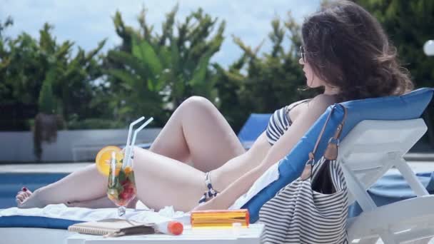 Young lady in bikini sunbathing on deck chair, enjoying vacation - Materiał filmowy, wideo