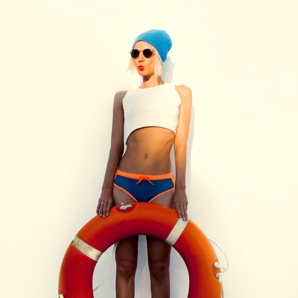 Funny blonde on wall background with lifebuoy - Foto, afbeelding