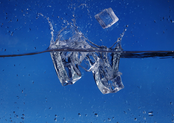 Ice cubes splashing into water, close-up - Fotó, kép