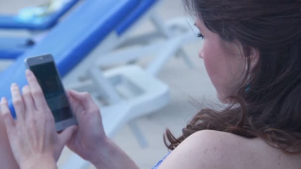 Young pretty woman at beach starting phone call, conversation - Video, Çekim