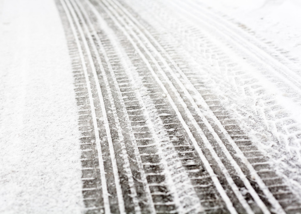 Ίχνη τροχών στο δρόμο καλυμμένα με χιόνι - Φωτογραφία, εικόνα