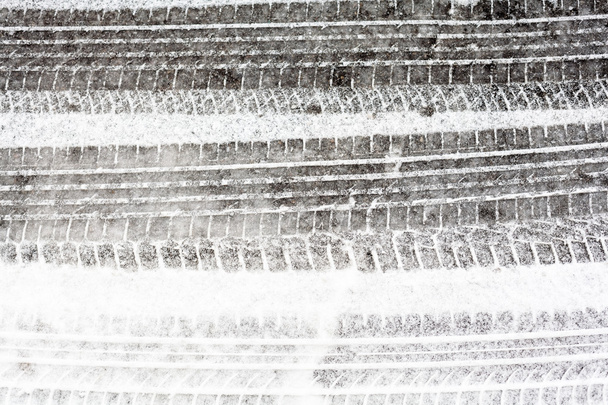 雪に覆われた道路上のホイールトラック - 写真・画像