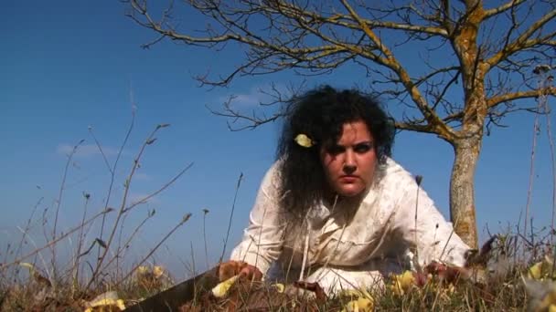 Божевільна жінка Повзуча на землі з пилкою на луг - Кадри, відео