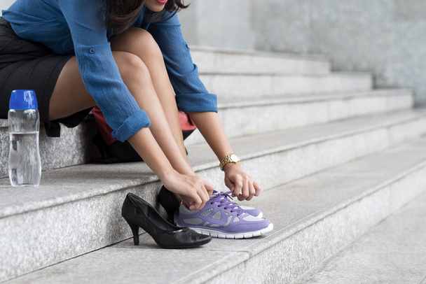 Vrouw schoenveters knopen op sneakers - Foto, afbeelding