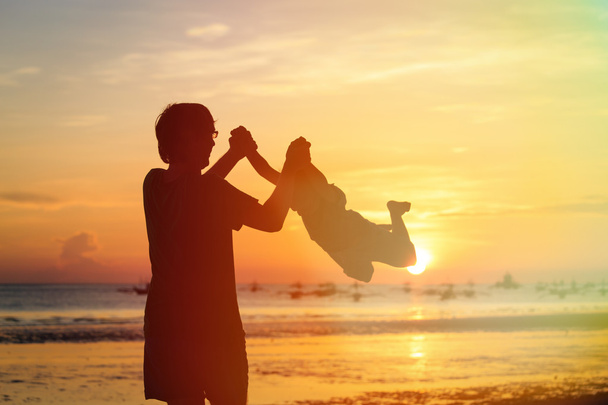 isä ja poika siluetit pelata auringonlaskun aikaan
 - Valokuva, kuva