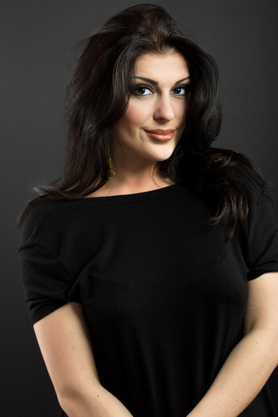 Attractive brunette on a black background. Portrait of a beautiful woman. - Foto, Imagen