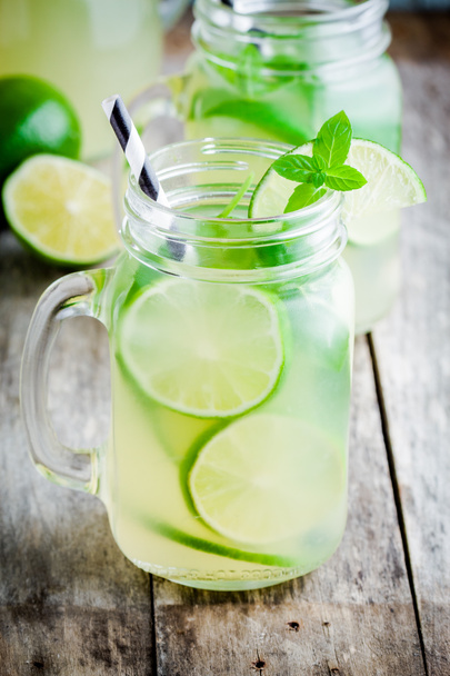 homemade lemonade with lime, mint in a mason jar on a wooden table - Photo, Image