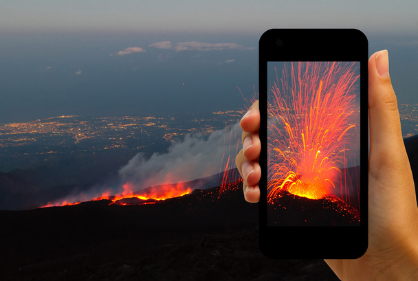 Tourist photographing the volcano eruption on smartphones - 写真・画像