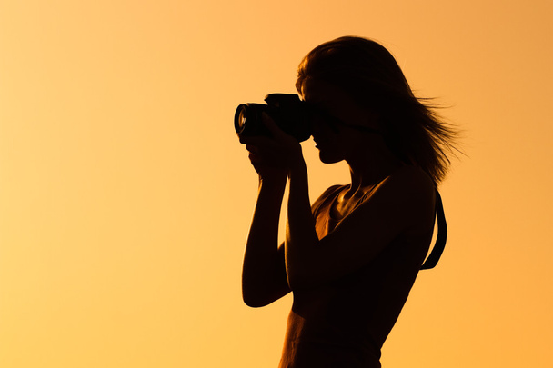 Silhouette of a woman photographing - Foto, Imagem