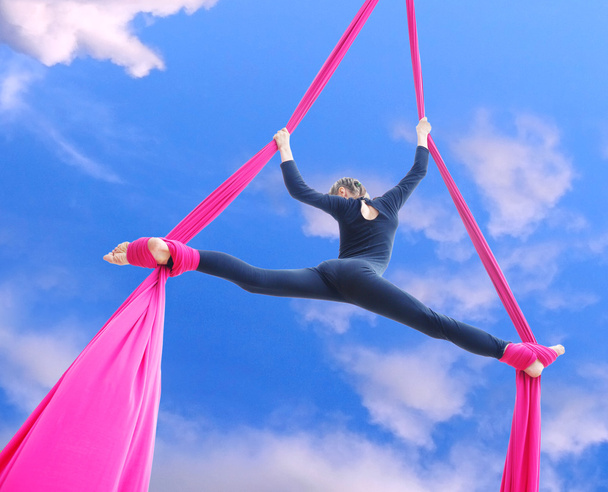cheerful child training on aerial silks in the sky - Valokuva, kuva