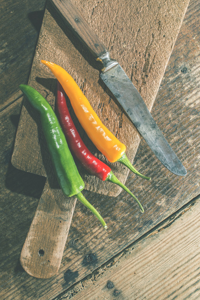 Hot peppers on wooden cutting board - Foto, Imagen
