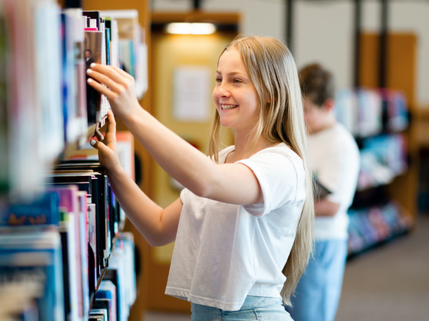 Teenage girl in library - Foto, Imagen