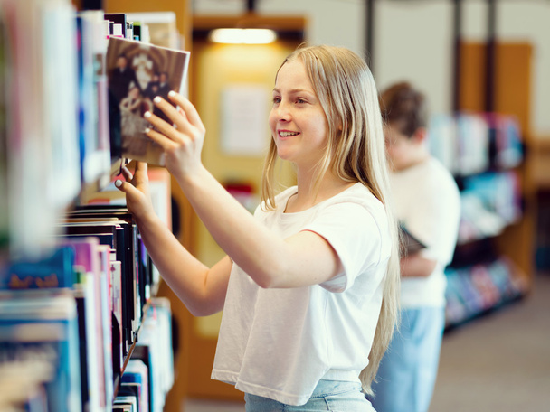 Teenage girl in library - Fotó, kép