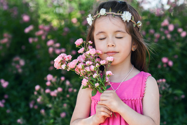 Portrait of beautiful little girl with roses flowers - Фото, изображение