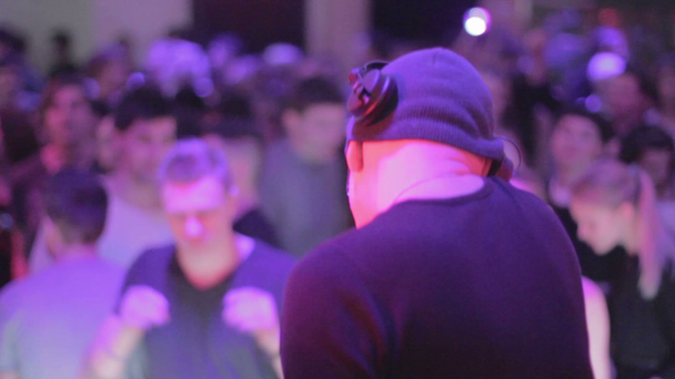Man playing music, DJ performing at night club, people dancing - Video, Çekim