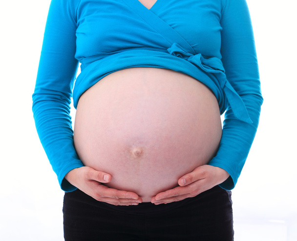 Έγκυος γυναίκα κρατά τα χέρια στο στομάχι - Φωτογραφία, εικόνα