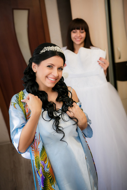 The bridesmaid helps the bride to be prepared for a wedding ceremony - Φωτογραφία, εικόνα