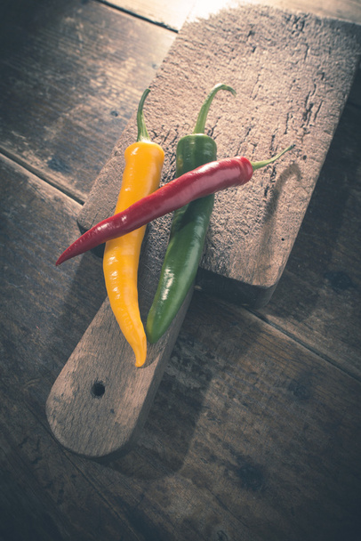 Hot peppers on wooden cutting board - Foto, imagen