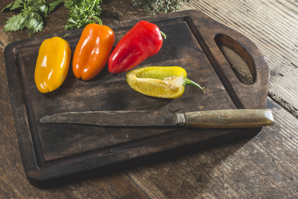 peppers on wooden board and knife - Fotografie, Obrázek