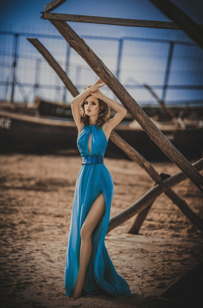 girl in long blue dress on a seashore - Foto, Imagen