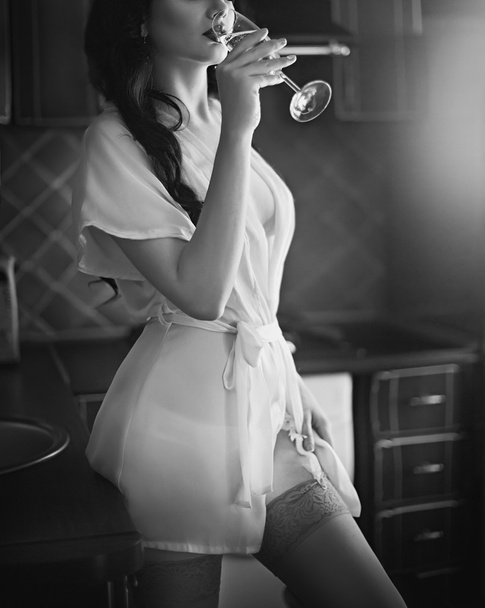 キッチンでワインを飲みながらのブルネットの少女 - 写真・画像