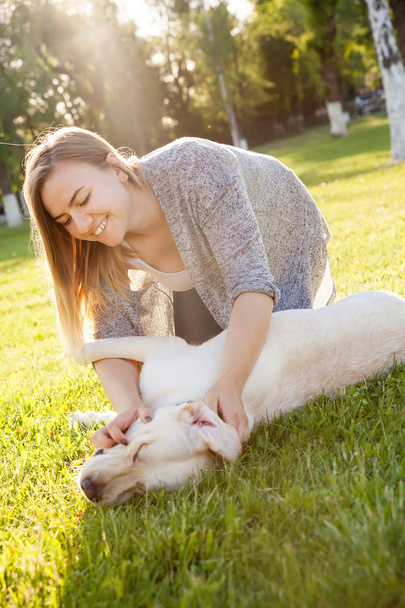 Beautiful woman playing with her dog Labrador retriever - Zdjęcie, obraz