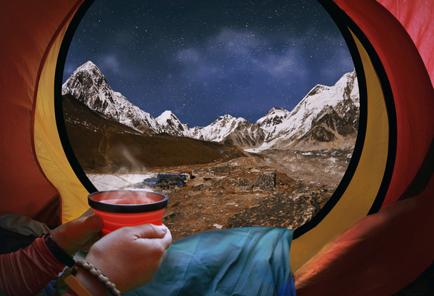 Жінка лежить в наметі з кавою, вид на гори і ніч с
 - Фото, зображення