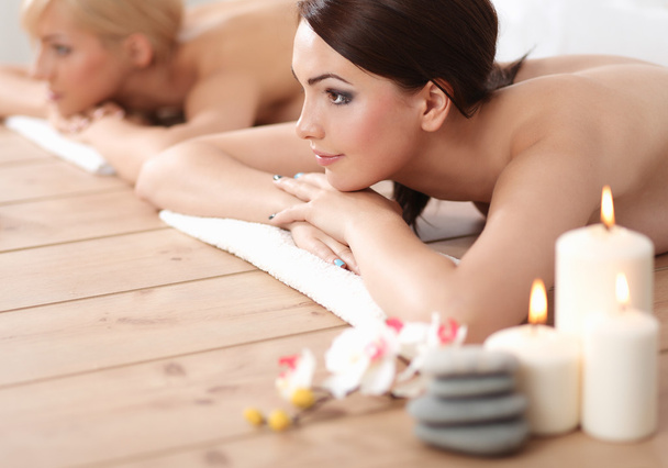 Two young beautiful women relaxing and enjoying at the spa center - Fotó, kép