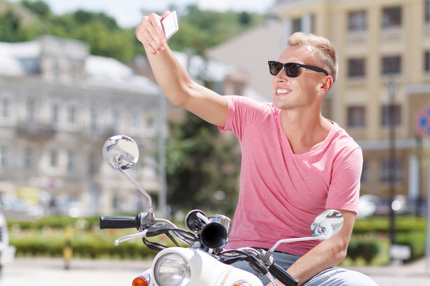Giovane bello facendo selfie su scooter
 - Foto, immagini