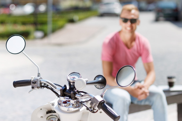 Smiling man sitting behind his scooter - Foto, Bild