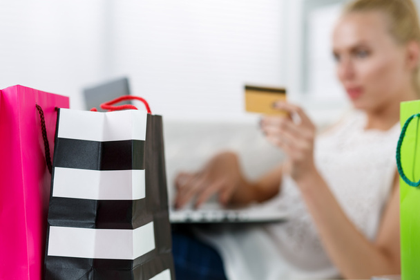 Mujer rubia haciendo compras vía internet pagando con tarjeta de crédito
 - Foto, imagen