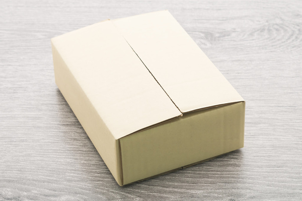 Паперова коробка на фоні дерева
 - Фото, зображення