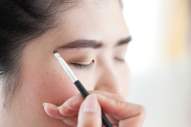Make-up Schönheit mit Pinsel Augenbraue auf hübsche Frau - Foto, Bild