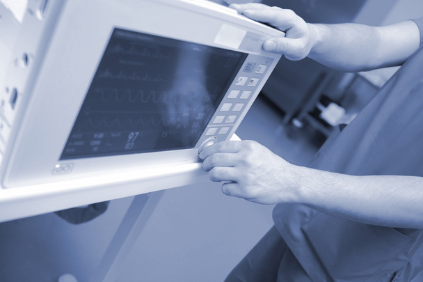 El médico ajusta el monitor en el lecho de enfermedad
 - Foto, imagen